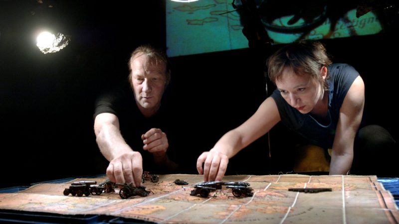 hotel-modern_image8 Members of Hotel Modern perform "The Great War" on stage, a white man and a white woman moving toy cannons across a map of Europe.