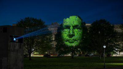  Floyd resident Tara Orlando's face is projected onto a tall tree on Virginia Tech's Drillfield as part of projection installation "Monuments" by artist Craig Walsh