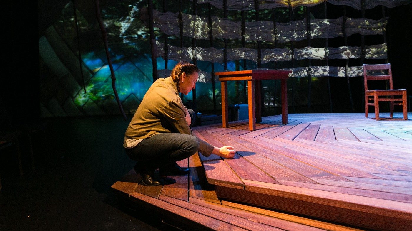  Actor DeLanna Studi crouched onto wooden decking during her one-woman play, "And So We Walked," about the Trail of Tears