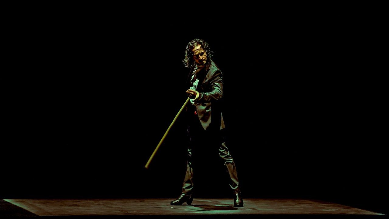  Flamenco dancer Farruquito wears a black suit and holds a cane while performing on stage.