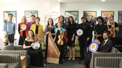 Members of the Itraab Arabic Music Ensemble wear concert attire and hold their instruments in the Moss Arts Center green room.