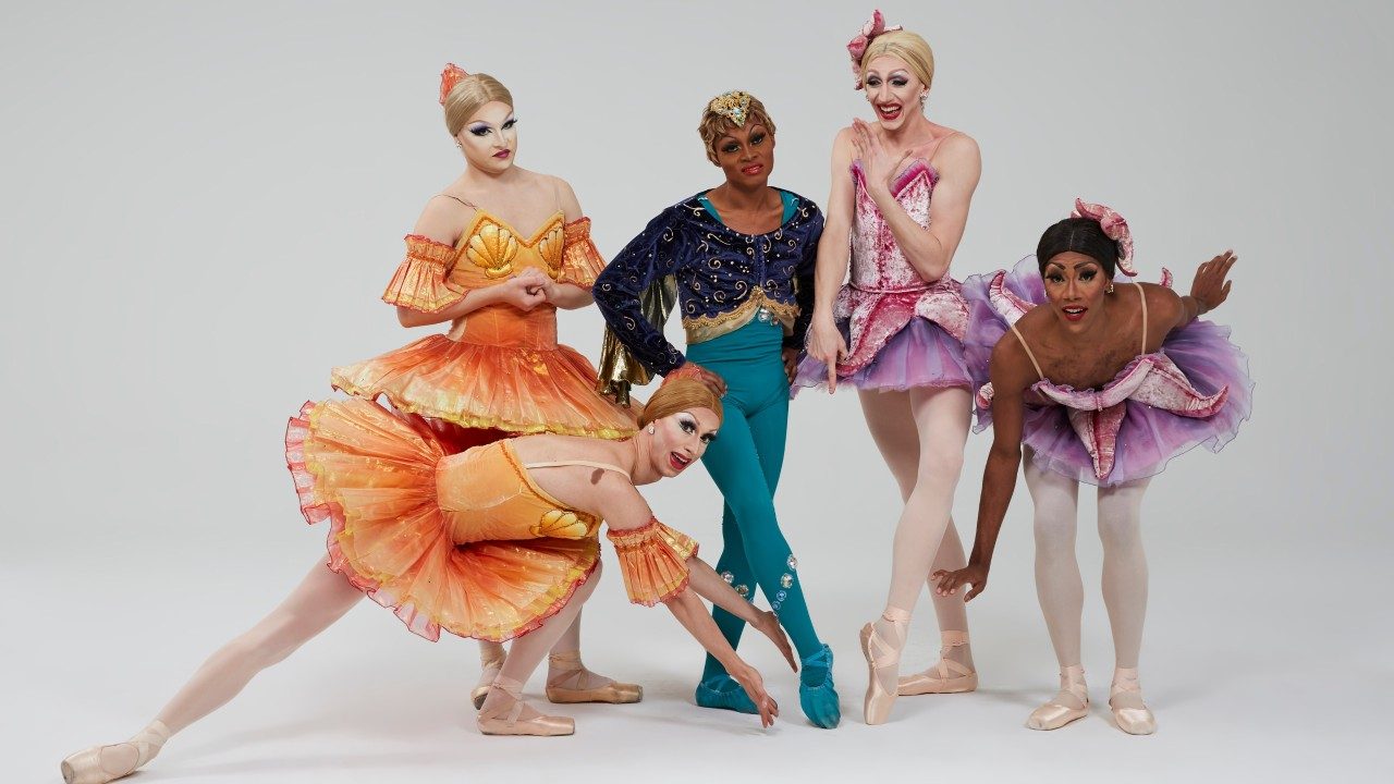  The dancers of Les Ballets Trockadero de Monte Carlo wear extravagant costumes, some of which seem to be inspired by sea creatures. The group consists of five men dressed in beautiful, detailed drag.