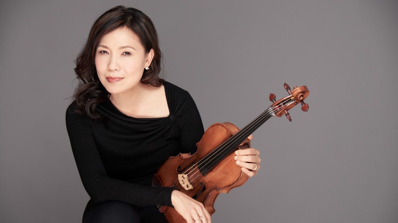  Violist Hsin Yun Huang, an Asian woman with medium length dark brown hair, wears a black shirt and holds her instrument against a medium grey background.