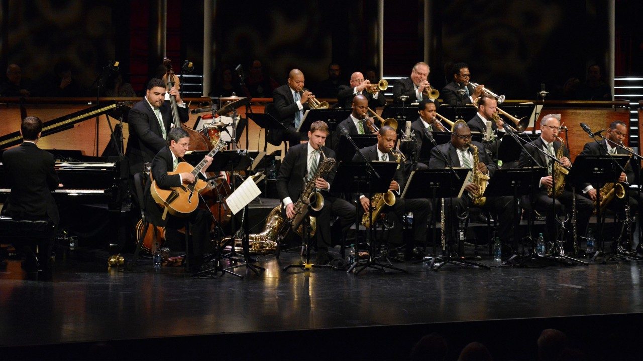  The Jazz at Lincoln Center Orchestra with Wynton Marsalis performs on stage. 17 musicians are pictured.