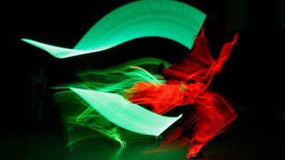 Abstract green and red light art forms appear to dance during Lightwire Theater's "Dino-Light."