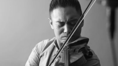 Violinist Adrian Anantawan, a member of the Music Inclusion Ensemble. Adrian is an Asian man with dark hair.