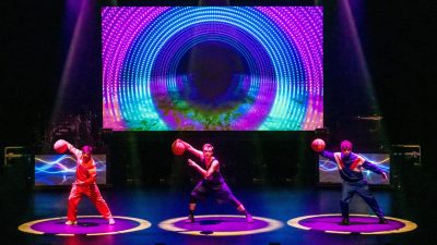 Members of 360 ALLSTARS perform on stage, each dribbling a basketball, all in sync.