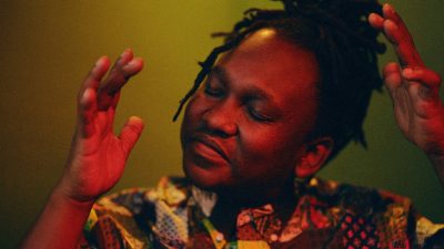 South African cellist Abel Selaocoe lifts his hands, his eyes closed as he feels the music.