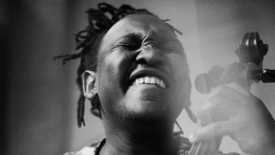 South African cellist Abel Selaocoe plays his cello, his eyes closed as he feels the music in this black and white image.