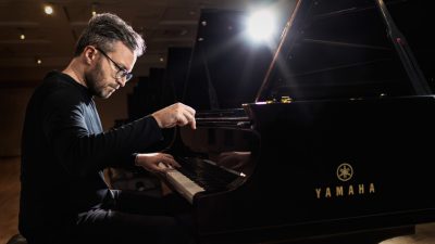 Pianist Conor Hanick, a middle aged white man, performs on stage.