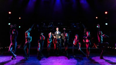 The cast members of "Chicago" perform on stage.