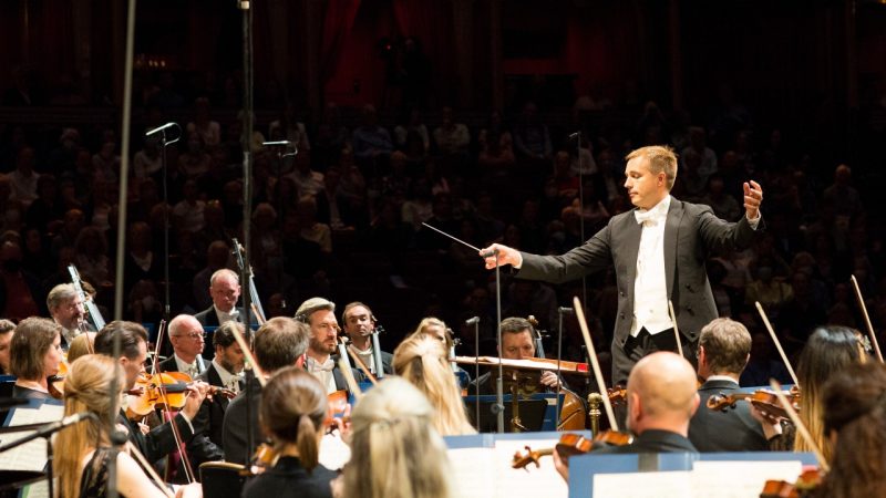 Music Director Vasily Petrenko leads the Royal Philharmonic Orchestra in a performance on stage.