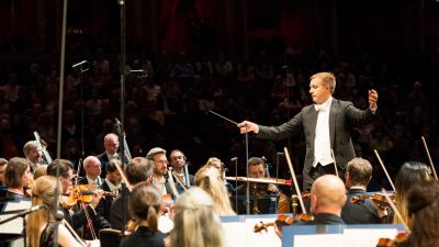 Music Director Vasily Petrenko leads the Royal Philharmonic Orchestra in a performance on stage.