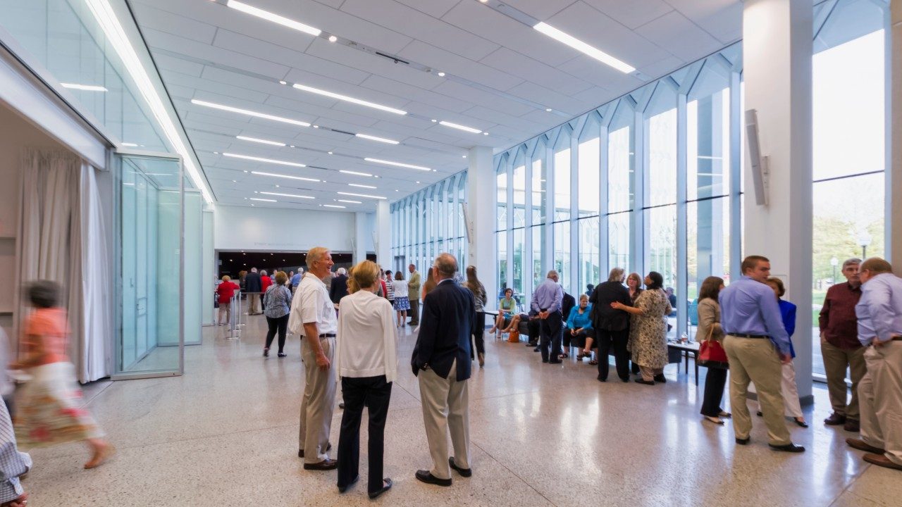  Patrons mingle in Moss Arts Center's grand lobby on a bright, sunny day.