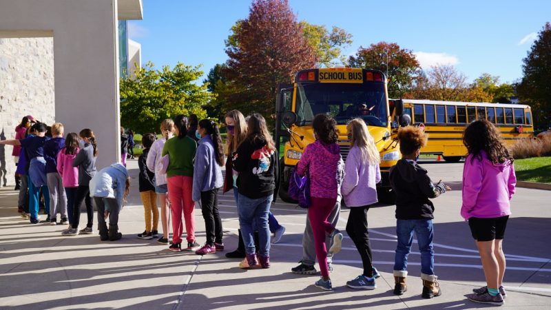 Students arrive at the Moss Arts Center for a free school-day matinee on a clear fall morning. Behind them, two school buses wait in the circular driveway.