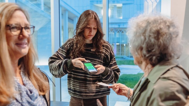 A Virginia Tech student employee scans tickets before a performance.