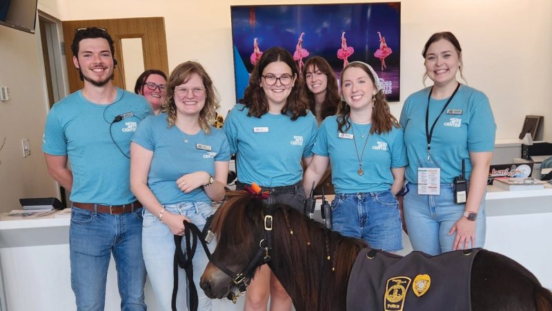 Moss Arts Center box office and front of house staff, many of whom are Virginia Tech students, pose with Ringo the Patrol Pony in front of the box office.